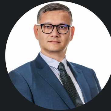 Professional man in suit and glasses posing confidently.
