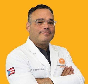 Confident male doctor in white coat with Puerto Rican flag patch.