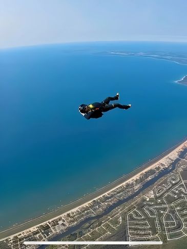 Solo skydiver in freefall over a town