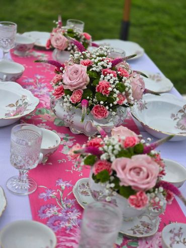 Elegant floral table setting with pink roses and delicate china.