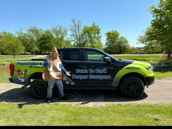 Person in poop costume stands next to a dog waste removal service truck.