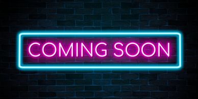 Neon sign displaying 'COMING SOON' in bright pink and blue colors.