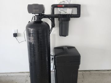 Home water softener system with salt tank and control valve.