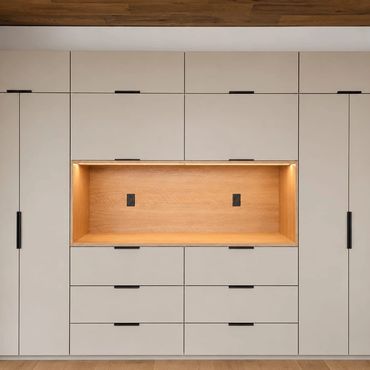 Modern built-in storage unit with lighting and wood accents.