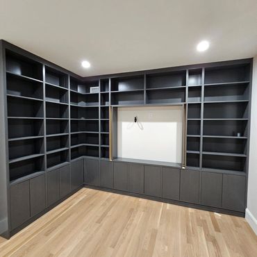 Empty dark gray corner shelves with lower cabinets in a room.