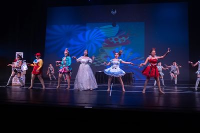 Children performing a colorful stage play with costumes and props.