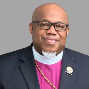Portrait of a man wearing religious attire and glasses.