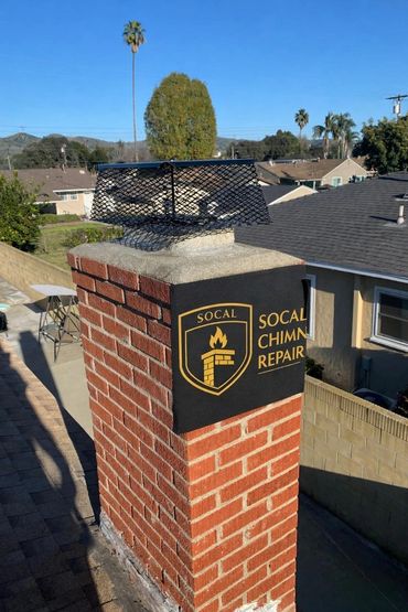 Brick chimney with SoCal Chimney Repair logo on a sunny day.