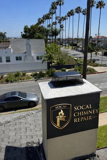 Chimney with SoCal Chimney Repair sign on a sunny suburban street.