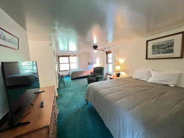 Master bedroom. One king sized bed and one full sized bed. A full bathroom, and vanity area in room.