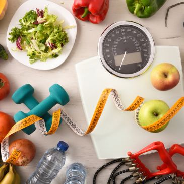 Healthy lifestyle items including fruits, dumbbells, and a weighing scale.