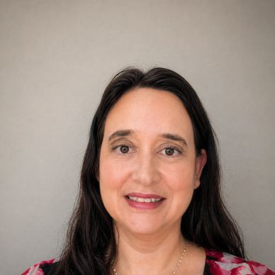 Smiling woman with dark hair and a patterned top.