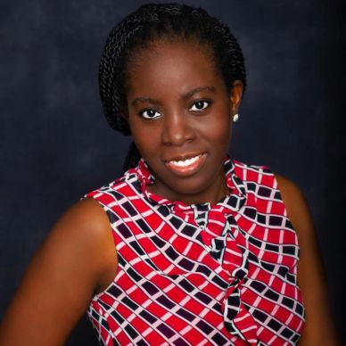 Woman smiling in a patterned red and white sleeveless top.