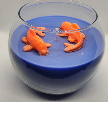 Blue candle in a glass bowl with two orange fish-shaped wax figures.