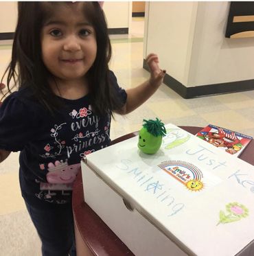 A patient receiving a box full of toys and activities during a hospital visit.