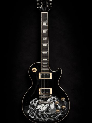 Black electric guitar with artistic octopus design on body.