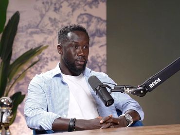 Podcaster interviewing a guest in a Dubai podcast studio.