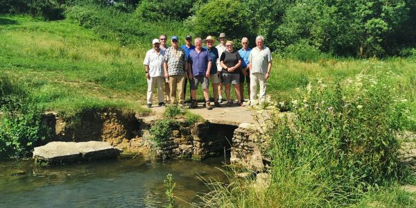 Group standing on a small stone bridge over a stream.