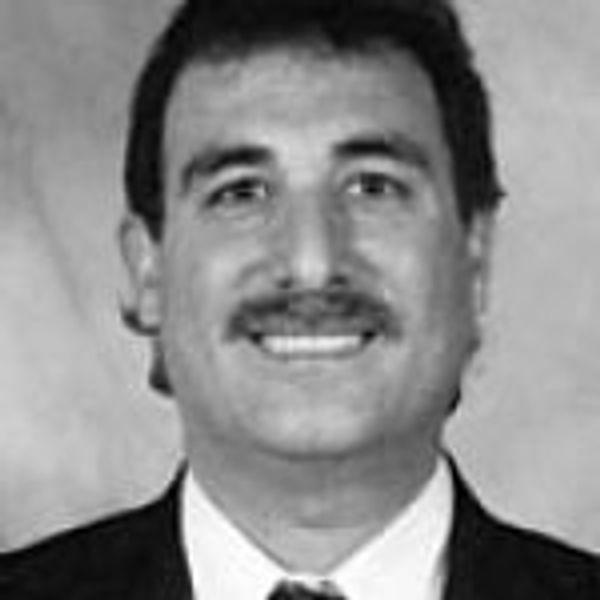 Black-and-white headshot of a man with a mustache in formal attire.