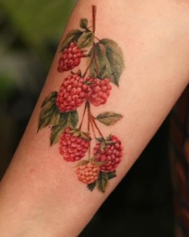 Beautiful colour realism raspberry tattoo