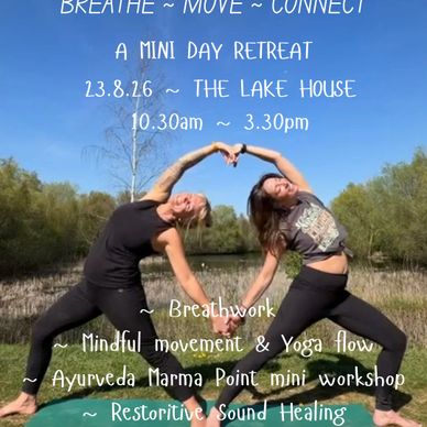 Two women practicing yoga outdoors forming a heart shape with their arms.