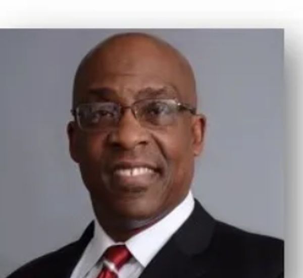 Smiling man in glasses and suit.