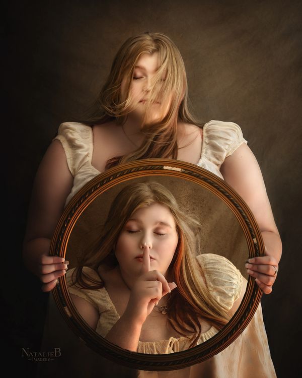 blonde girl holding a round mirror with herself in the reflection