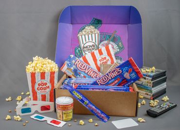 Movie night essentials including popcorn, Red Vines, 3D glasses, and DVDs.