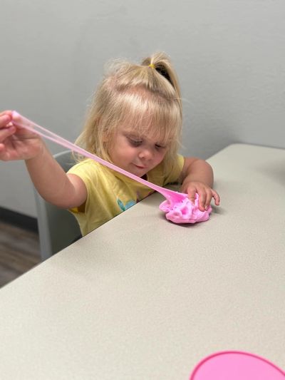 Child stretching and playing with slime during occupational therapy