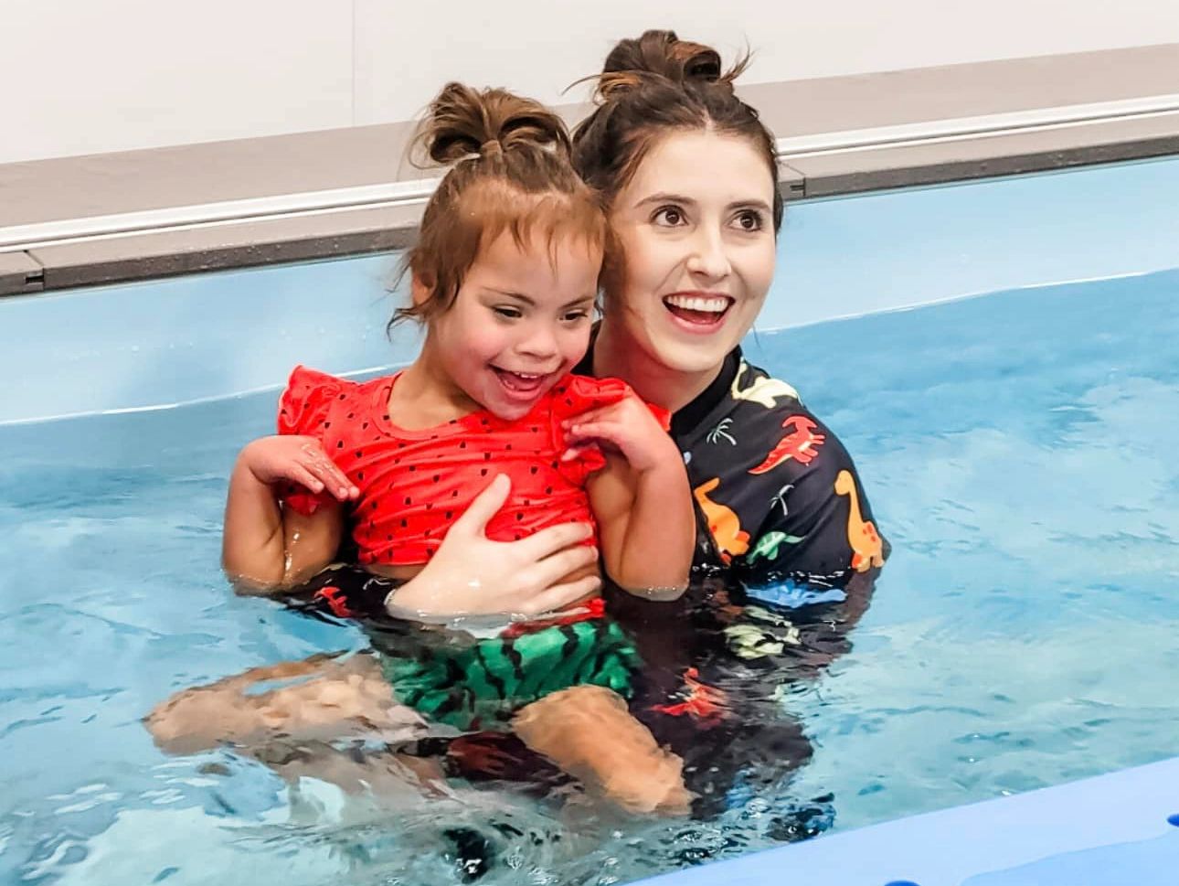 occupational therapist and child smiling in the pool during aquatics therapy