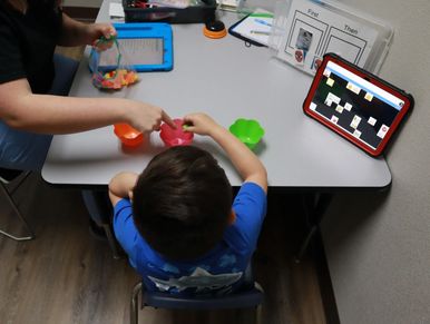 Child and registered behavior technician running interventions during ABA therapy