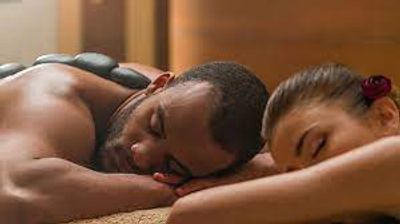 Couple enjoying hot stone massage together.