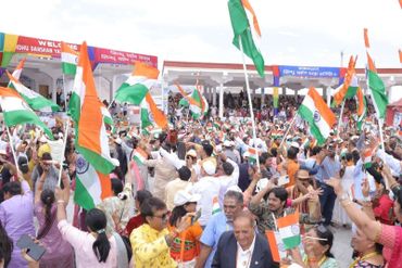 Crowd waving Indian flags at a patriotic gathering.