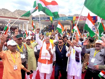 A lively group waving Indian flags at a cultural festival.