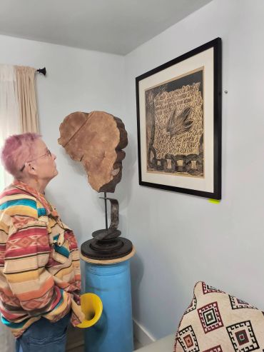 Person viewing artwork in a room.