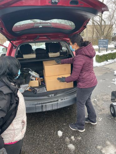Mission Belly Full meals are being loaded into SUV for donation.