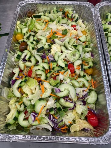 Mission Belly Full meals being prepared for donation. Large salad.