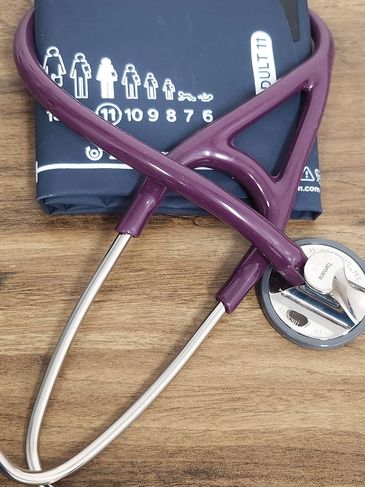 A stethoscope and blood pressure cuff on a wooden surface.