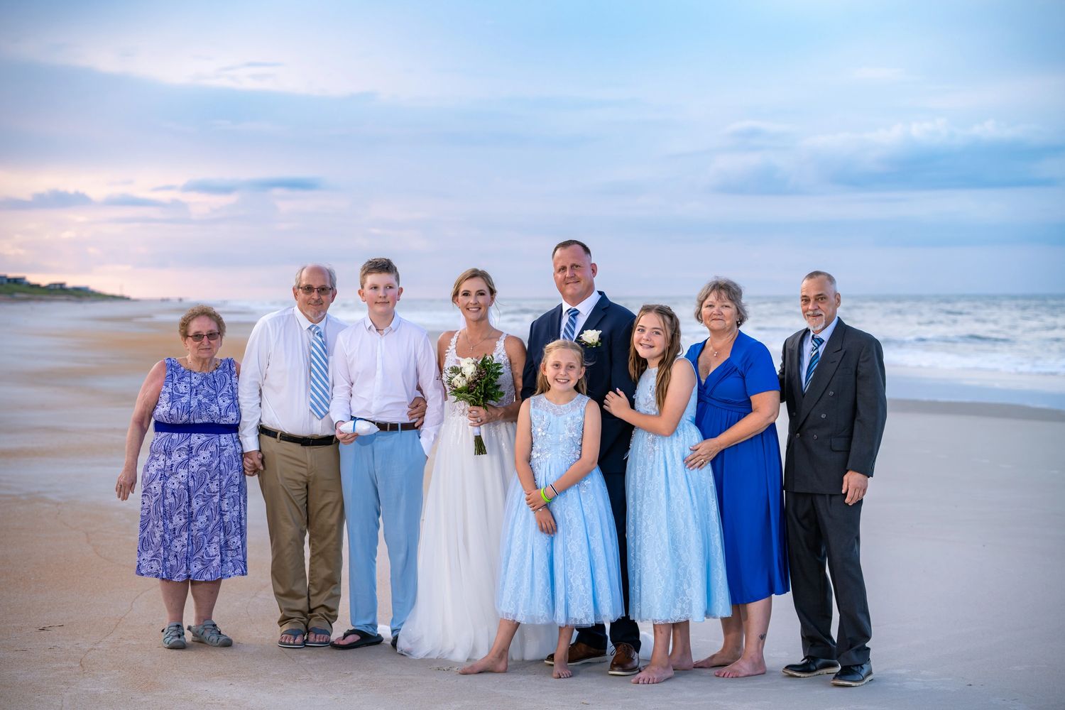 Happy newlyweds and damily on beach