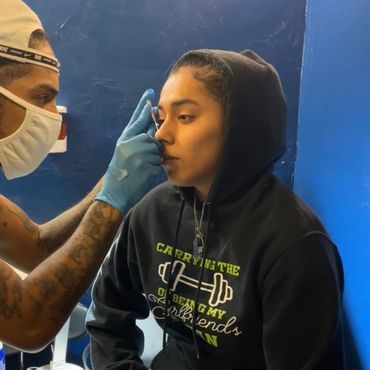 eric doing nose piercing at indigo tattoo shop