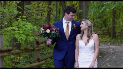 Bride and groom walking in a forest path.
