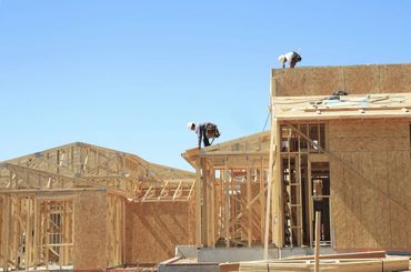 Luxury Services NM carpenter measuring and cutting lumber for framing work