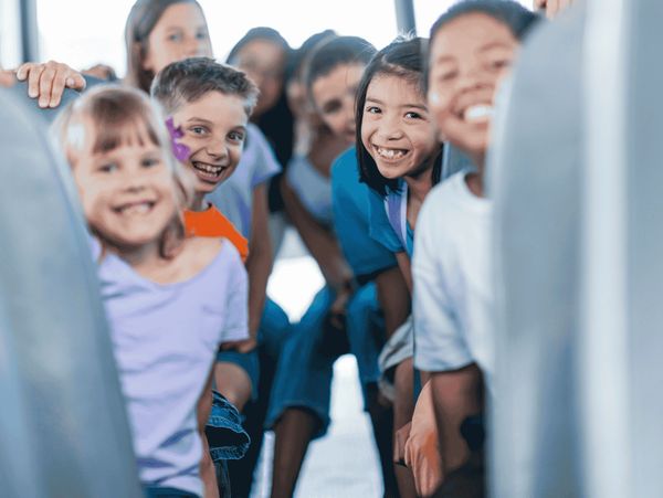 Children smiling on a school bus