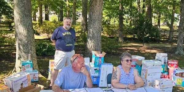 A deacon and two parishioners give out free diapers to the church's neighbors in need