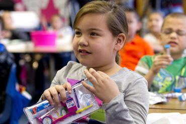 little girl with tooth decay prevention kit