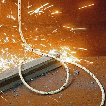 Promotional BlueWater Ropes ArmorTech™ heat resistant rope in industrial work setting.