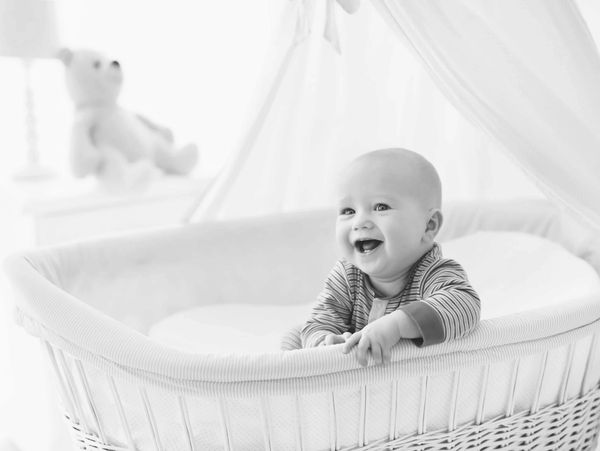 Baby smiling in bassinet