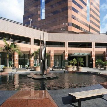 Modern courtyard with a reflective water feature and abstract sculpture.