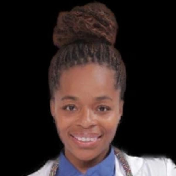 Smiling woman with braided hair in a bun against black background.