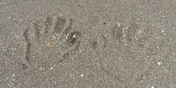 Two small hand-prints in the sand
